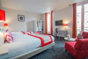 a hotel room with a bed and a red chair at Hôtel Amaryllis in Nice