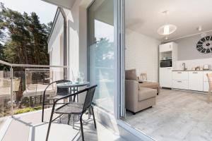 a room with a balcony with a table and chairs at Villa Ula Apartament in Pobierowo