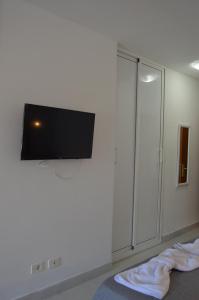 Un dormitorio con un televisor de pantalla plana en la pared. en Apartamento Tobago, en Puerto Rico de Gran Canaria