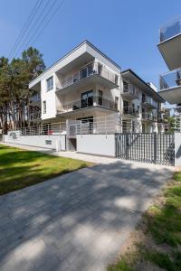 an apartment building with a fence in front of it at Villa Ula Apartament in Pobierowo