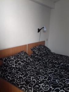 un letto con una coperta bianca e nera e una lampada di Къща Момина сълза a Sapareva Banya