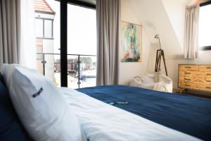 sypialnia z łóżkiem i dużym oknem w obiekcie Apartamenty Port Ustka w Ustce