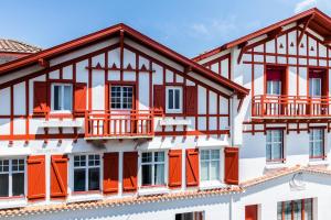 a red brick building with a red roof and windows at Best Western Kemaris in Biarritz