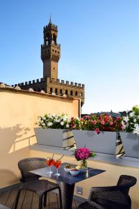 a table with a clock on top of it next to a garden at San Firenze Suites & Spa in Florence