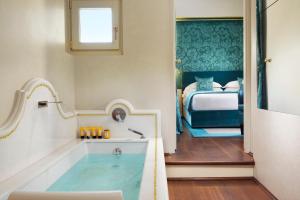 a bath room with a tub and a window at San Firenze Suites & Spa in Florence