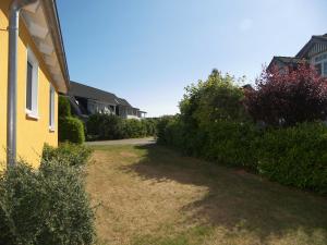 トラッセンハイデにあるFerienwohnung Trassenheideの茂みのある黄色い家の隣の庭