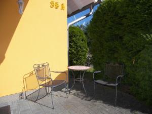 a patio with two chairs and a table and a yellow wall at Ferienwohnung Trassenheide in Trassenheide +27 photos