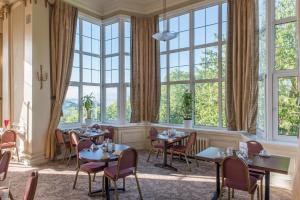 a dining room table with chairs in front of a window at Cumbria Grand Hotel in Grange Over Sands