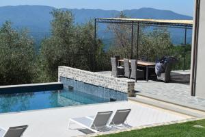 Villa La Braja في Licciana Nardi: مسبح مع كراسي وطاولة على فناء