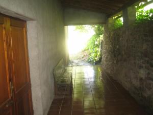 um corredor vazio com uma parede de pedra e uma porta em Cal Font (RCP) em Pla de Sant Tirs