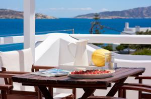 a table with a bowl of fruit and a drink at Mirabeli Apartments & Suites in Pollonia