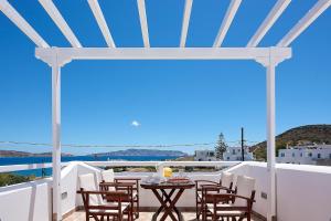 a patio with a table and chairs on a balcony at Mirabeli Apartments & Suites in Pollonia
