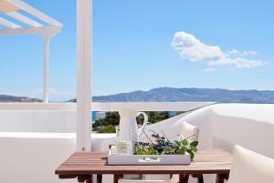 a table with a vase and flowers on a balcony at Mirabeli Apartments & Suites in Pollonia