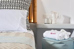 a bedroom with a bed with a sink and towels at Mirabeli Apartments & Suites in Pollonia