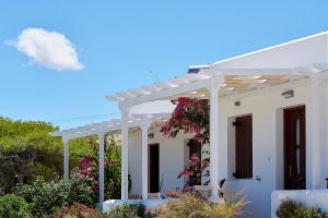 a white house with a white pergola at Mirabeli Apartments & Suites in Pollonia