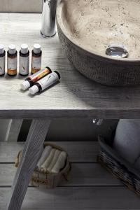 a shelf with a sink and some bottles of cosmetics at Mirabeli Apartments & Suites in Pollonia