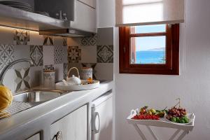- une cuisine avec évier et plateau de fruits dans l'établissement Mirabeli Apartments & Suites, à Pollonia 37 autres photos