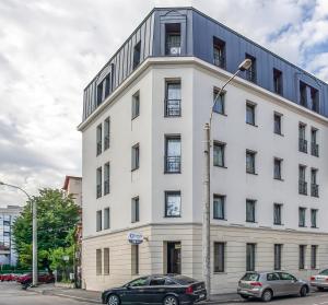 un edificio blanco con coches estacionados frente a él en Venis Boutique Hotel, en Bucarest