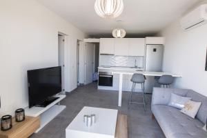 a living room with a couch and a kitchen at bungalow con gran terraza con vistas in Maspalomas