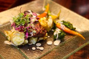 a plate of food with vegetables on a table at Rhino Post Safari Lodge in Skukuza