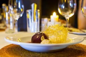 a plate of food on a table with wine glasses at Rhino Post Safari Lodge in Skukuza