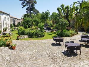 eine Terrasse mit Tischen und Stühlen in einem Garten in der Unterkunft Domaine de Chantageasse in Asnières-la-Giraud + 15 Fotos