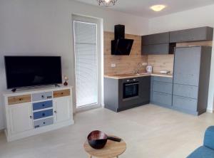 a living room with a kitchen with a flat screen tv at Lorena in Cres
