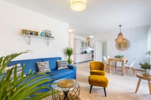 uma sala de estar com um sofá azul e uma cadeira amarela em Lux Apartment Medulin Istria em Medulin