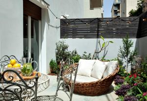 a patio with a wicker chair and a table at Mr. Katinsky - By TLV2GO in Tel Aviv