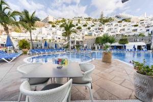 - une table et des chaises à côté de la piscine dans l'établissement Bahia Blanca, à Puerto Rico