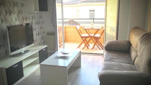 salon z kanapą, telewizorem i stołem w obiekcie Apartamento "El Abuelo" w mieście Calahorra