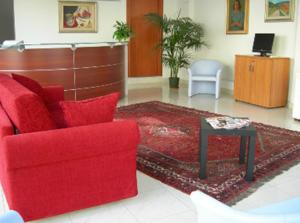 ein Wohnzimmer mit einem roten Sofa und einem Tisch in der Unterkunft Residence Montegrappa in Cagliari