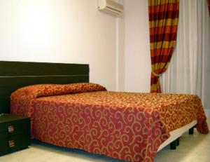 a bedroom with a bed with a red comforter at Residence Montegrappa in Cagliari