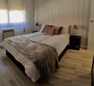 duże łóżko w sypialni z drewnianą podłogą w obiekcie Apartamento "El Abuelo" VT-LR560 w mieście Calahorra