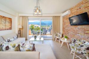 een woonkamer met een bank en een bakstenen muur bij Luxury Villa Fotini in Limenas