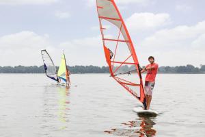 drie mensen windsurfen op het water bij RCN Zeewolde in Zeewolde