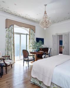 una camera con letto, tavolo e sedie di Villa Margherita by Belmond a Ravello