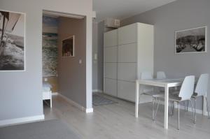 a dining room with a white table and chairs at Apartament 45 Baltic Park Pogorzelica in Pogorzelica