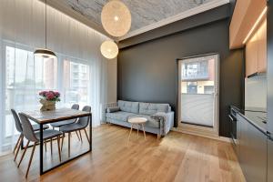 a living room with a table and a couch at Apartamenty Apartinfo Chmielna Park in Gdańsk