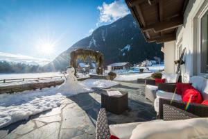 a snowman is sitting on a patio with the sun at Hotel Antholzerhof in Anterselva di Mezzo