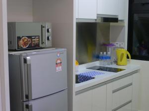 a kitchen with a microwave and a refrigerator at KiddyPalace@Meridin in Nusajaya