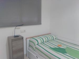- une chambre avec un lit et une table de nuit dans l'établissement Airem 22, à Roquetas de Mar
