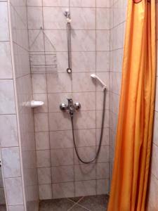 eine Dusche mit orangefarbenem Duschvorhang im Bad in der Unterkunft Apartmani Tonica in Sukošan