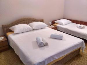 sypialnia z 2 łóżkami i białymi ręcznikami w obiekcie Apartmani Tonica w Sukošanie