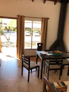a dining room with a table and chairs and a window at Arenas Termales in Salto