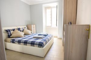 ein Schlafzimmer mit einem Bett mit einer blau-weißen Decke in der Unterkunft Appartamento Tadolini in Rom