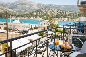 a balcony with a table with a glass of orange juice at Fidias city rooms in Argostoli