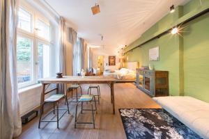 Zimmer mit einem Tisch, Stühlen und einem Bett in der Unterkunft Design Apartments - "Im Holländerhaus" in Potsdam