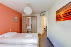 サン・ラファエルにあるAppartement centrale à 100 m des plages Rue de Provenceのオレンジ色の壁のベッドルーム1室(白いベッド1台付)
