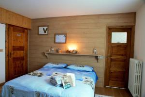 ein Schlafzimmer mit einem blauen Bett und einer Holzwand in der Unterkunft Chalet dell'Ermellino in Bormio
